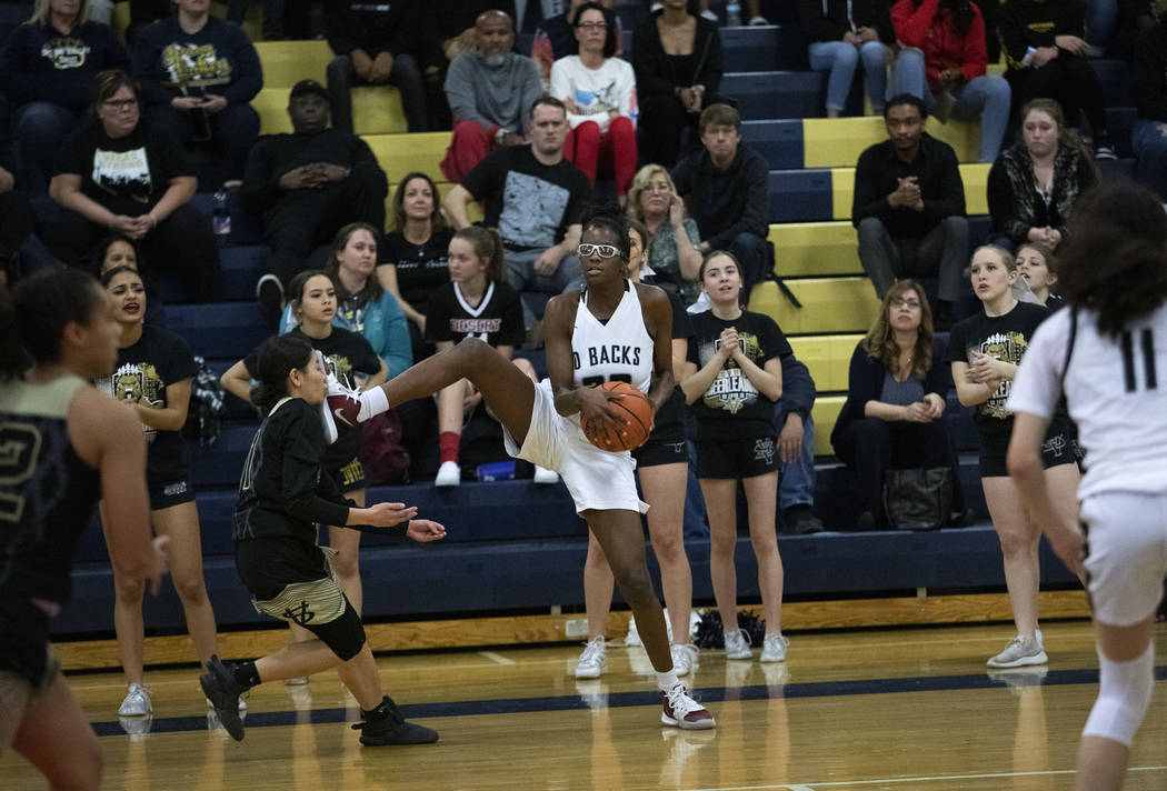 Desert Oasis's Desi-Rae Young (23) makes contact with the face of Spring Valley's center Kenna ...