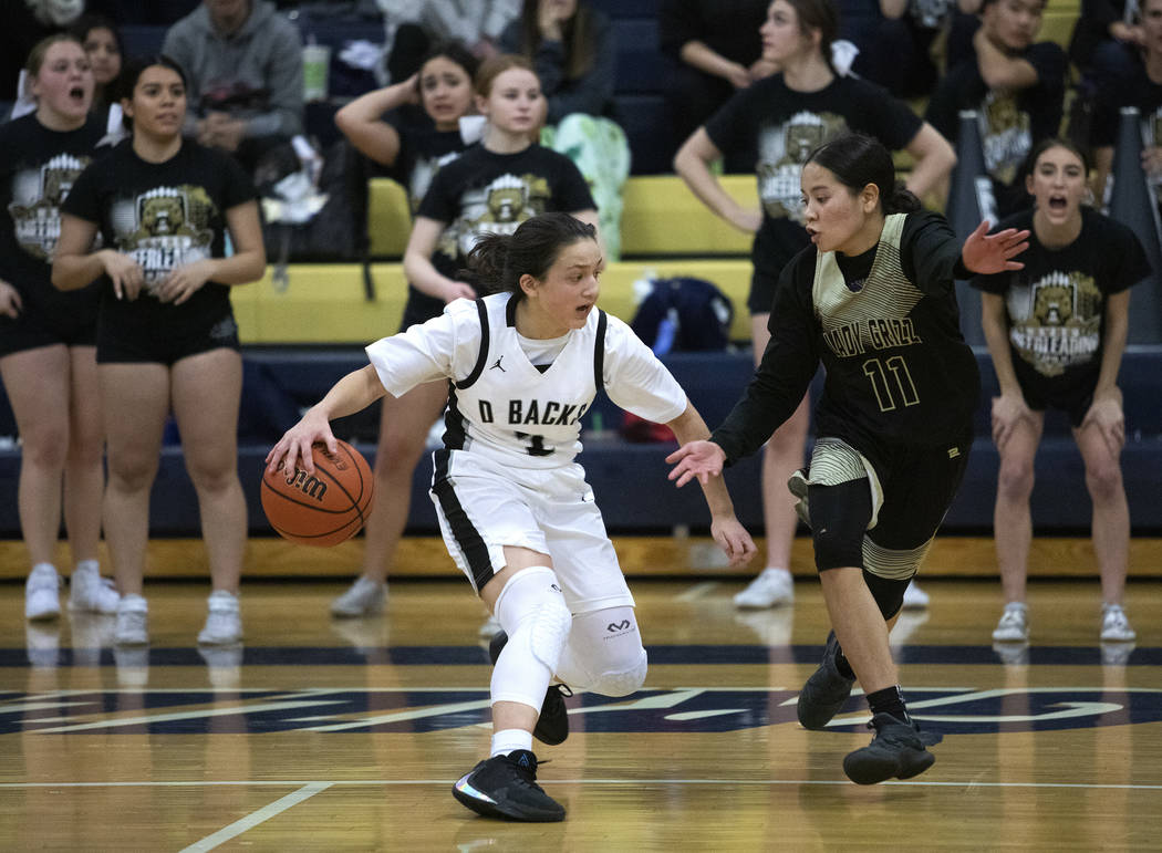 Desert Oasis's guard Autiyjah Pricebrooks (3) dribbles around Spring Valley's center Kenna Scot ...