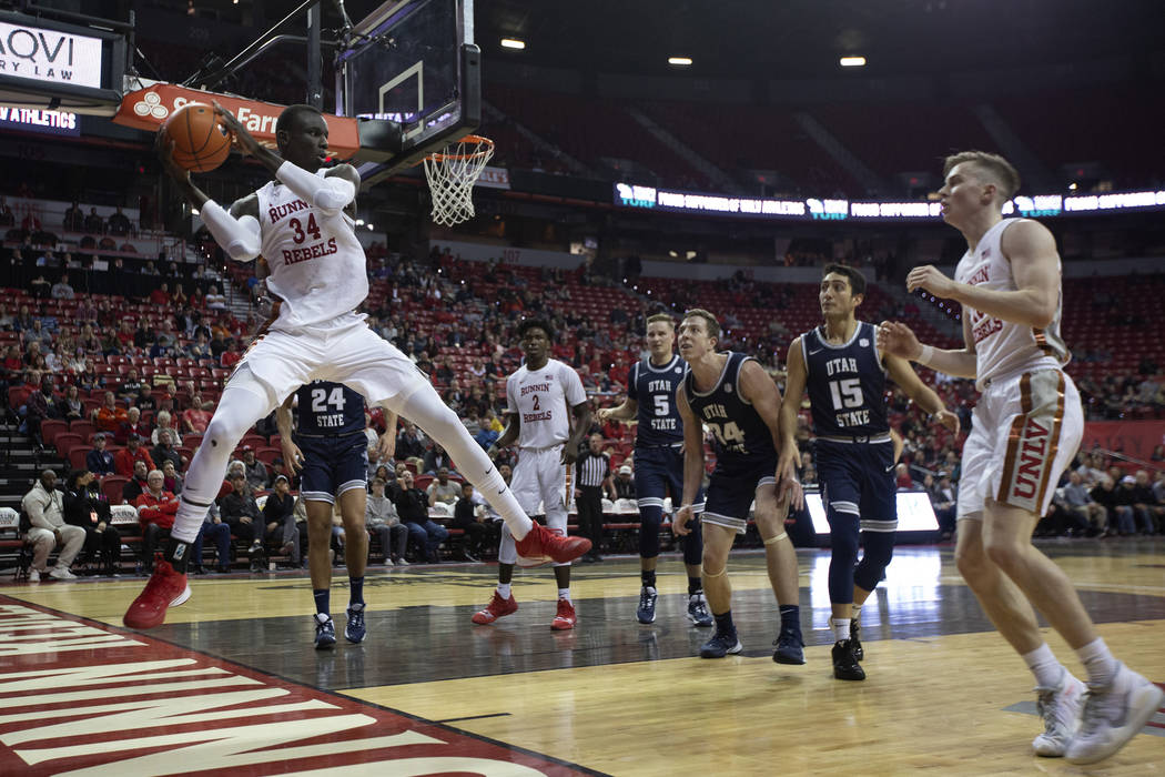 UNLV's forward Mbacke Diong (34) grabs the ball on defense as Utah State players look on during ...