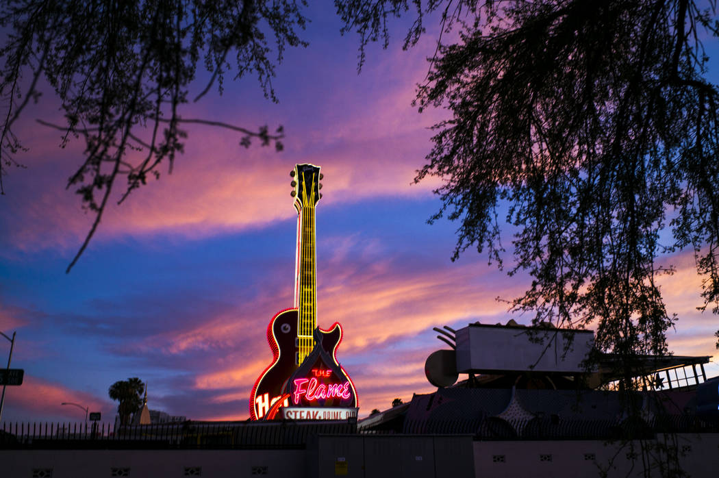 Vista de la guitarra del Hard Rock Cafe y los letreros de The Flame en el Neon Museum en el cen ...