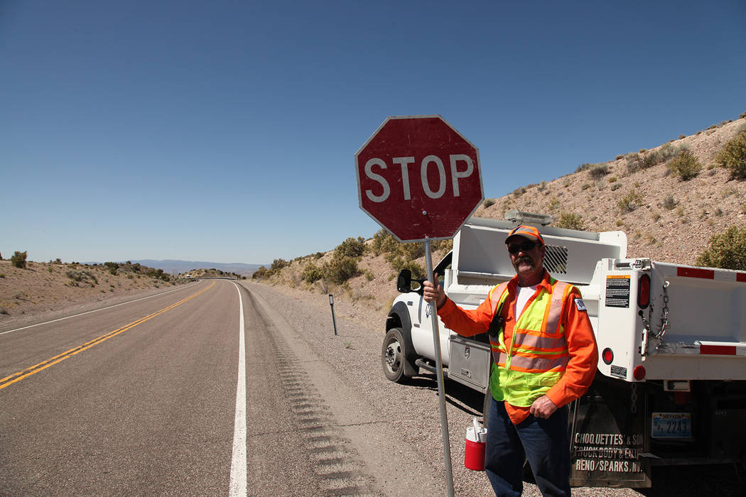 A Nevada Department of Transportation employee readies to stop traffic near a clean up project. ...