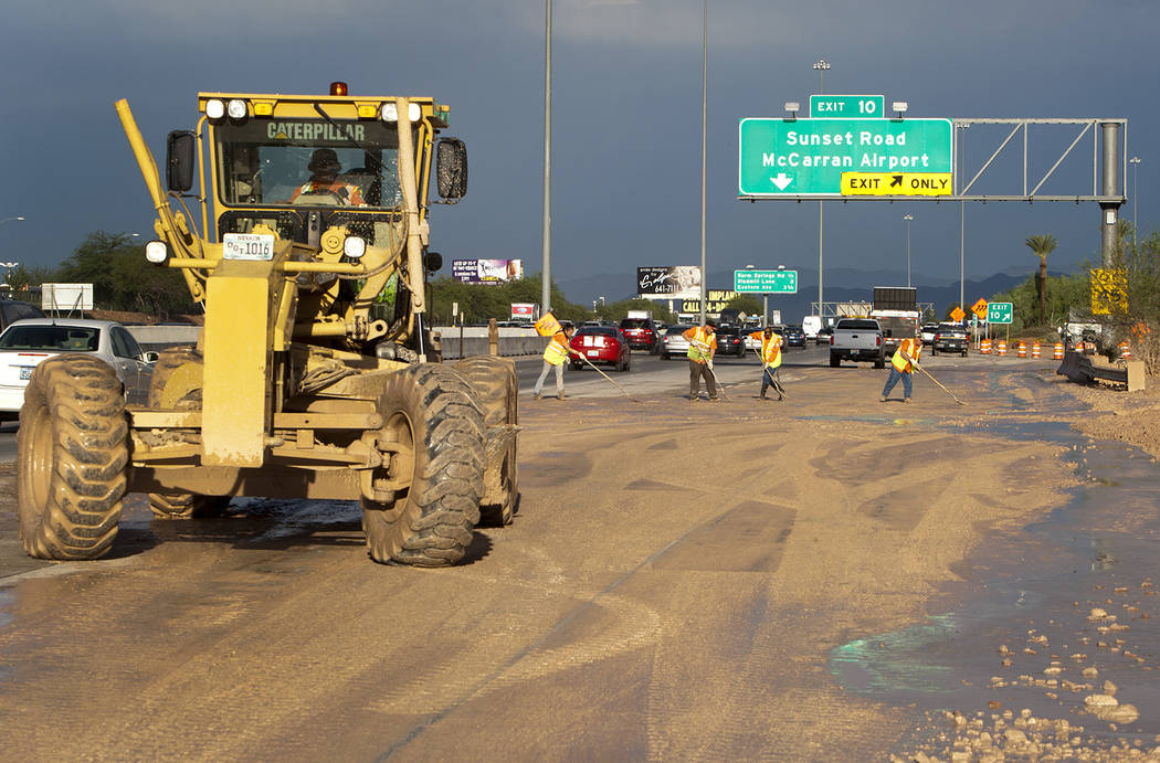 A Nevada Department of Transportation road crew works to clear the roadway at the I-215 eastbou ...