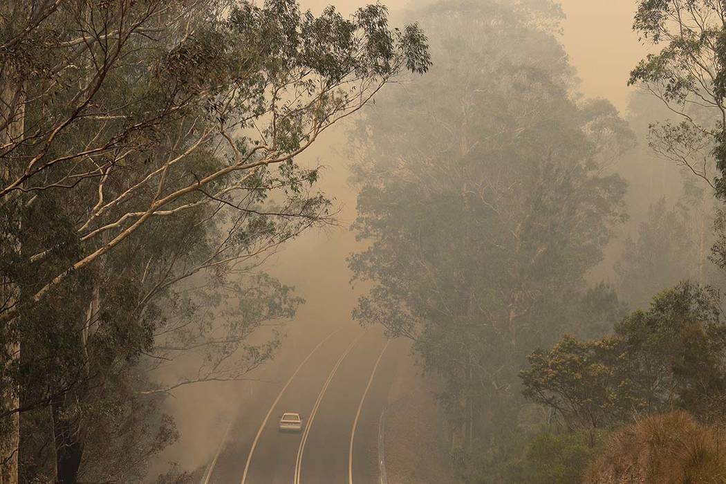 Smoke from wildfires shrouds a road near Moruya, Australia, Saturday, Jan. 4, 2020. Australia's ...