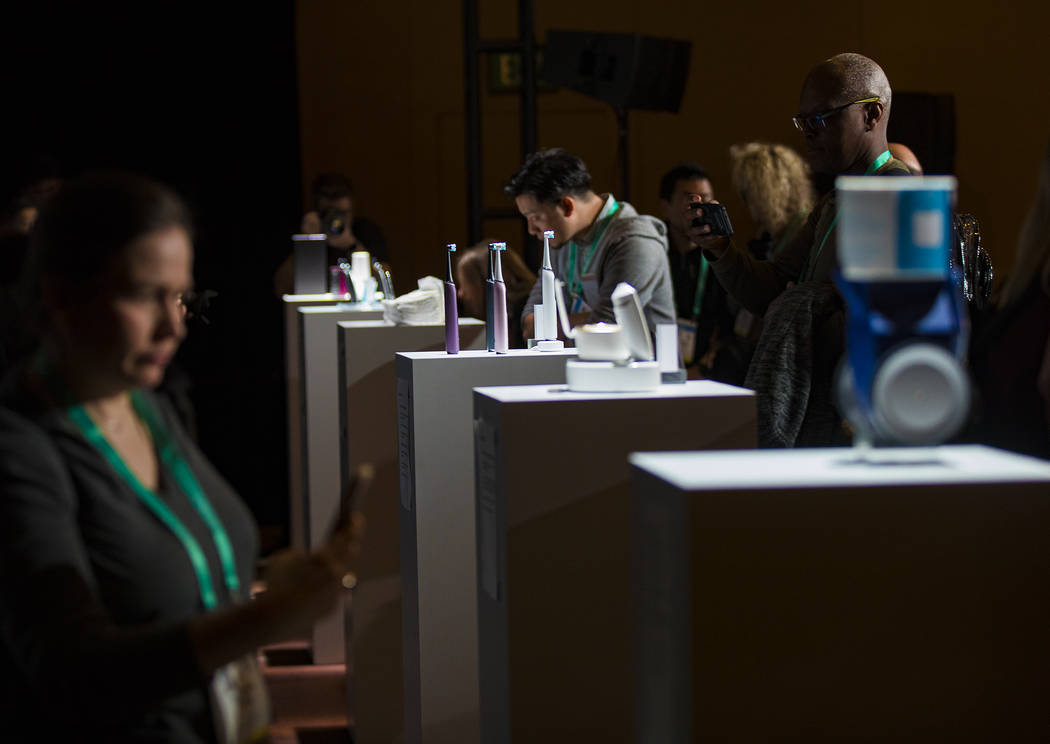 Members of the media look at products created by Procter & Gamble featured for CES at a med ...