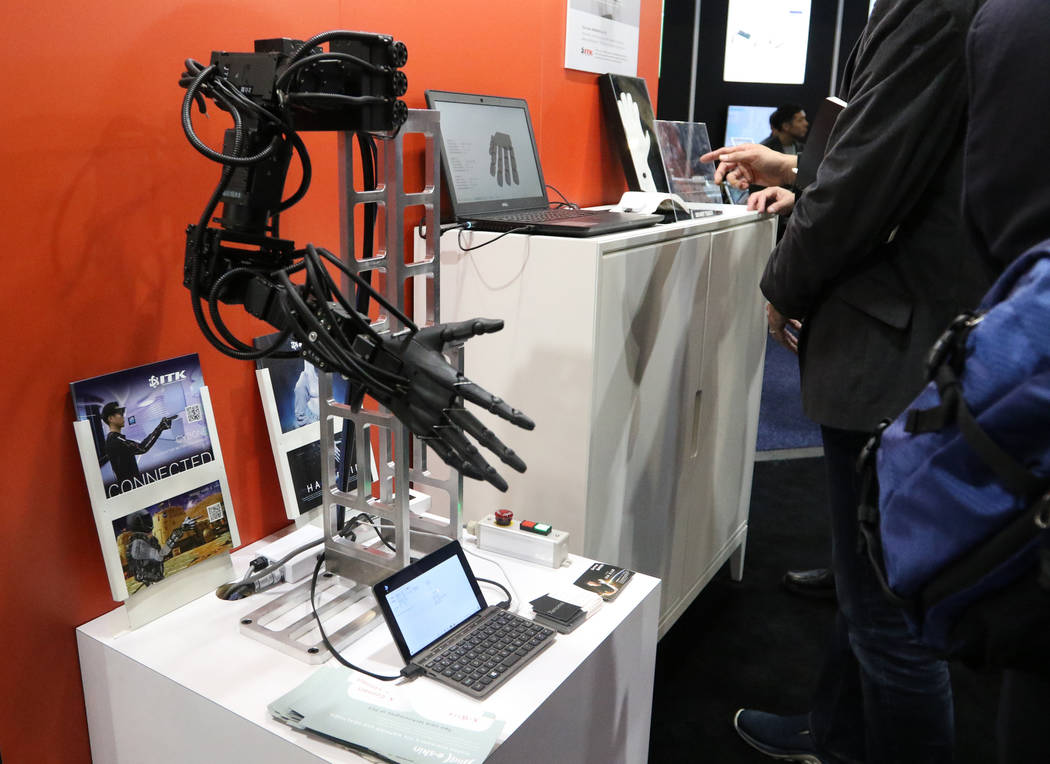 A robotic arm that shows how the E-Skin suit, a wearable fitness item, works on display at the ...