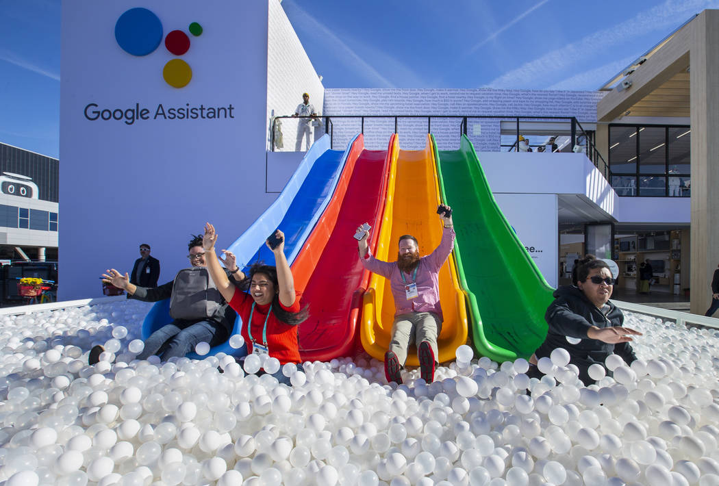 Robert McKenna, center, joins others inspiring down into a ball pit outside the Google display ...