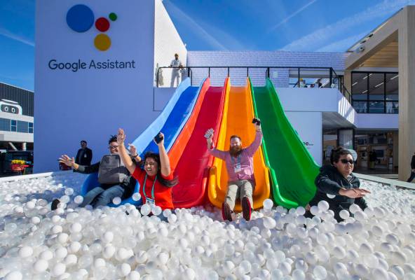 Robert McKenna, center, joins others inspiring down into a ball pit outside the Google display ...