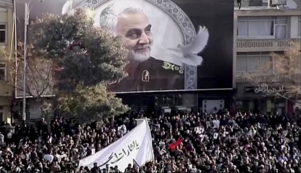 In this image made from a video, mourners gather to pay their respects to the slain Gen. Qassem ...