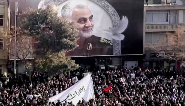 In this image made from a video, mourners gather to pay their respects to the slain Gen. Qassem ...