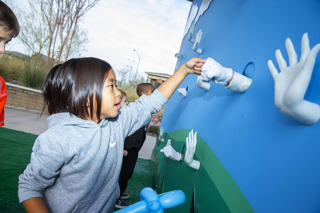 A child interacts with the Cadence high-five wall. (Studio J. Inc./Eric Jamison)