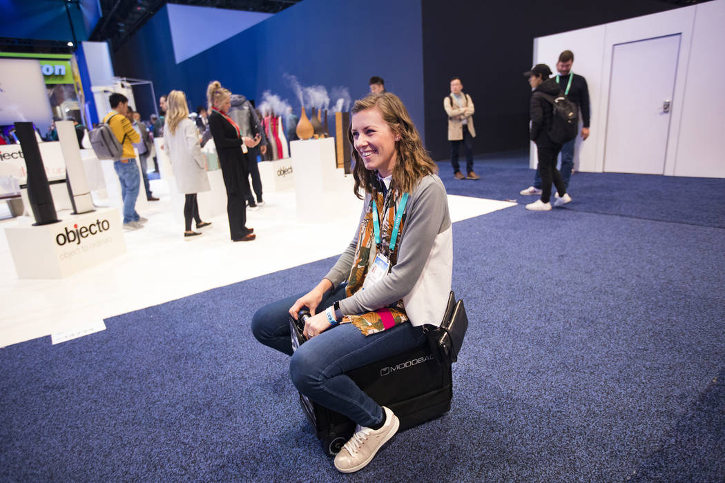 Chloe Richardson, from the U.K., tries out Modobag, a motorized carry-on at CES at the Las Vega ...