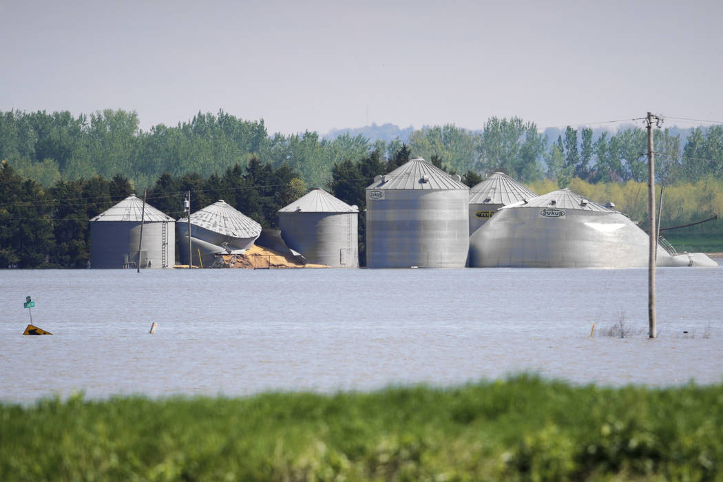 In this May 10, 2019, photo, grain bins belonging to Brett Adams are surrounded by flood waters ...