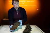 Alexandra Klingelhofer, executive director for collections, holds a pair of dress boots worn by ...