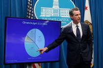 California Gov. Gavin Newsom gestures toward a chart showing funds he has allocated to climate ...