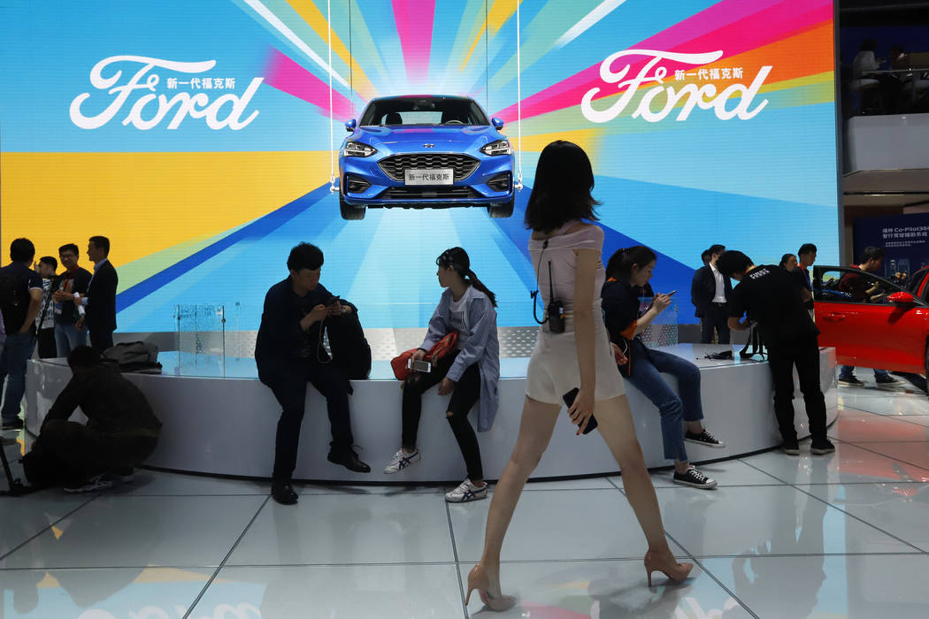 FILE - In this April 25, 2018, file photo, attendees visit the Ford booth during Auto China 201 ...