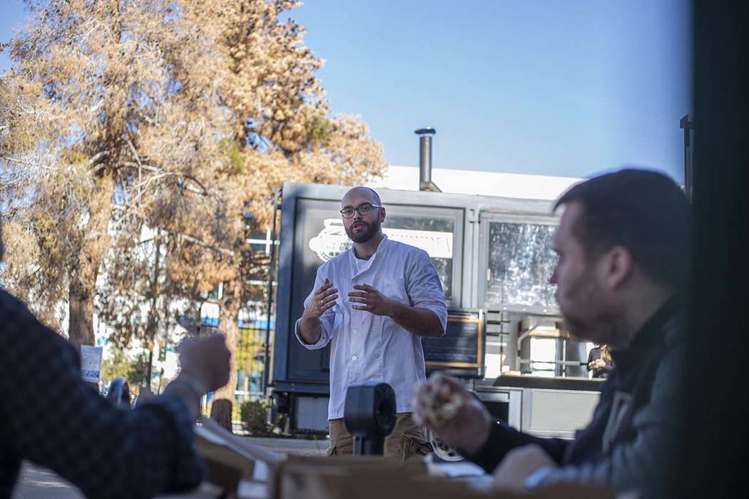 Chef Bartosz Wawrzyszak, owner of the Custom Pizza Truck, shares his story to costumers outside ...