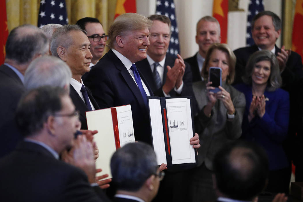 President Donald Trump, center, and Chinese Vice Premier Liu He, left, hold the U.S. China Trad ...