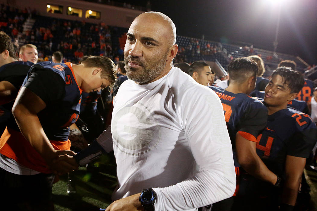 Bishop Gorman head coach Kenny Sanchez, center, shakes hands with players after their 34-7 win ...