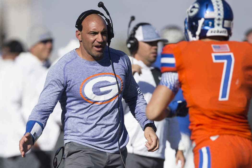 Bishop Gorman's head football coach Kenny Sanchez reaches his hand for Biaggio Walsh (7) after ...
