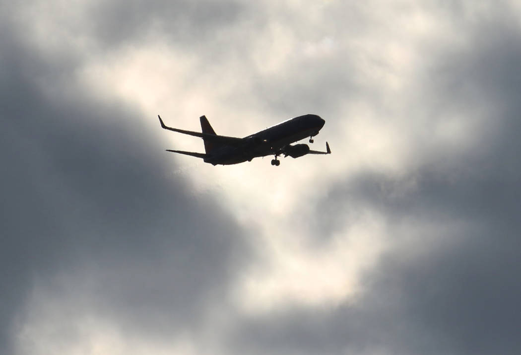 A Sun Country Airlines plane flies under cloudy sky as it approaches McCarran International Air ...