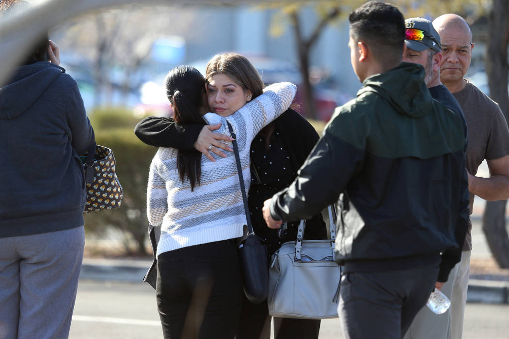 People embrace after leaving the scene of an officer-involved shooting that occurred in the 690 ...