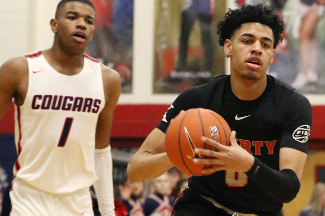 Coronado High's Jaden Hardy (1) watches as Liberty High's guard Julian Strawther (0) tries to p ...