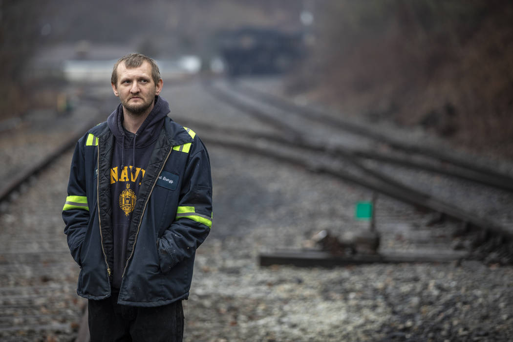 In this Tuesday, Jan. 14, 2020 photo, Timmy George, an employee of Quest Energy, stands on rail ...