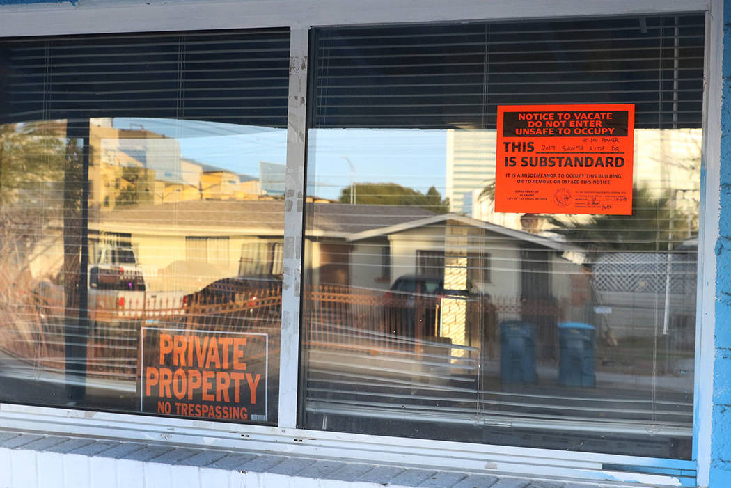 "Private Property" and "Unsafe to Occupy" signs are posted on the window of a house at 2017 S. ...