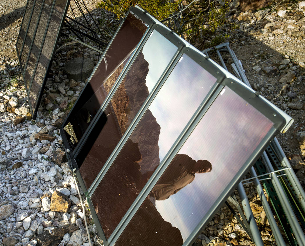 Richard Roman is reflected in one of his solar panels as he continues to clean out his cave aft ...