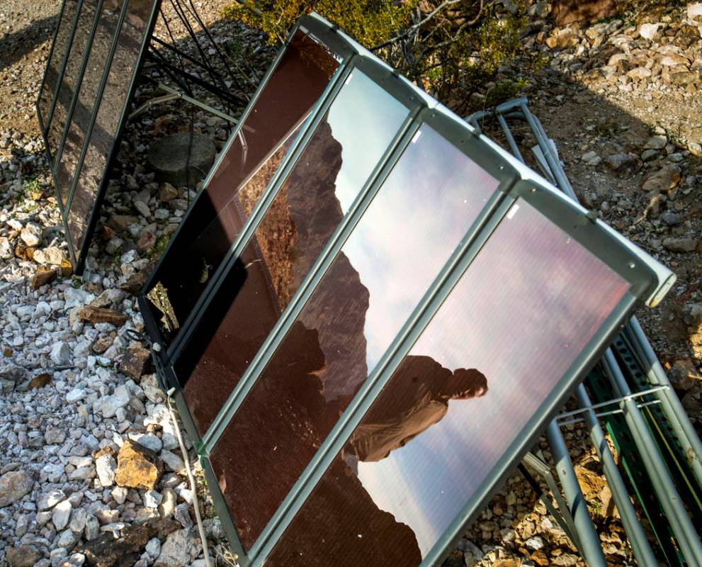 Richard Roman is reflected in one of his solar panels as he continues to clean out his cave aft ...