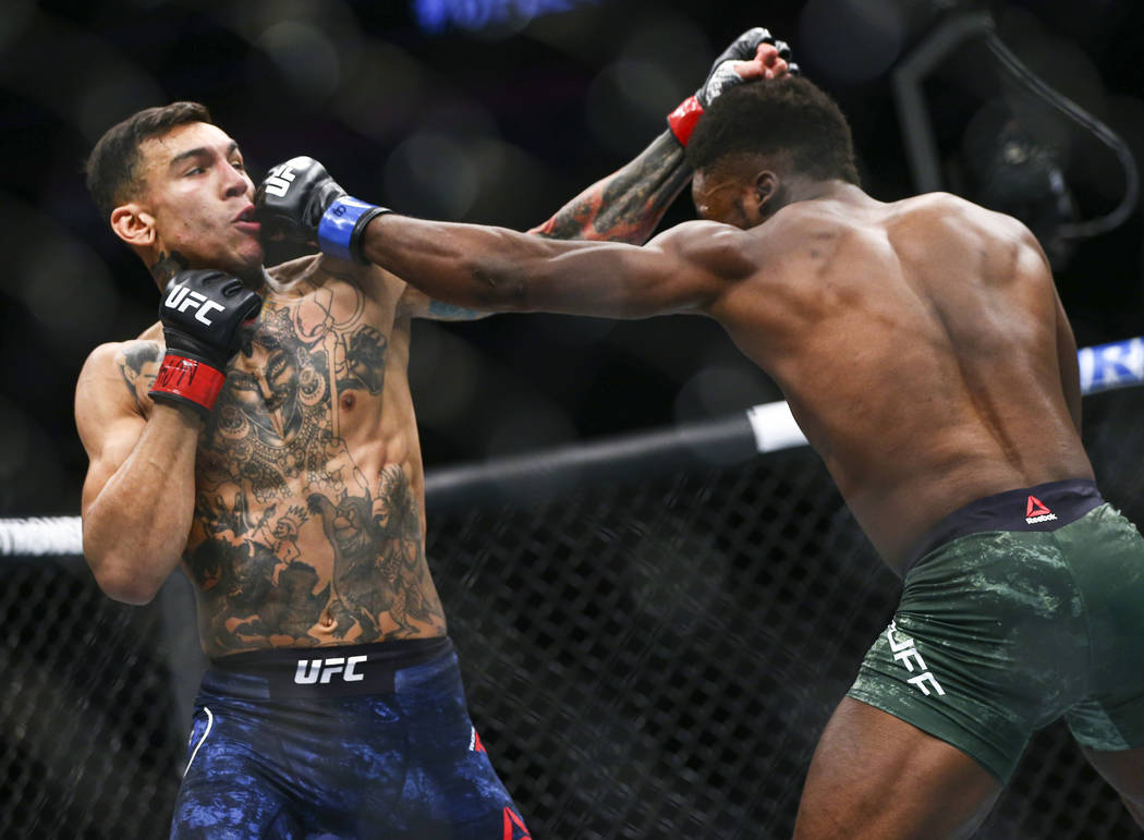 Andre Fili, left, takes a hit from Sodiq Yusuff during their featherweight bout at UFC 246 at T ...