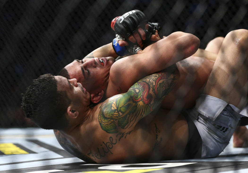 Diego Ferreira, left, fights Anthony Pettis during their lightweight bout at UFC 246 at T-Mobil ...