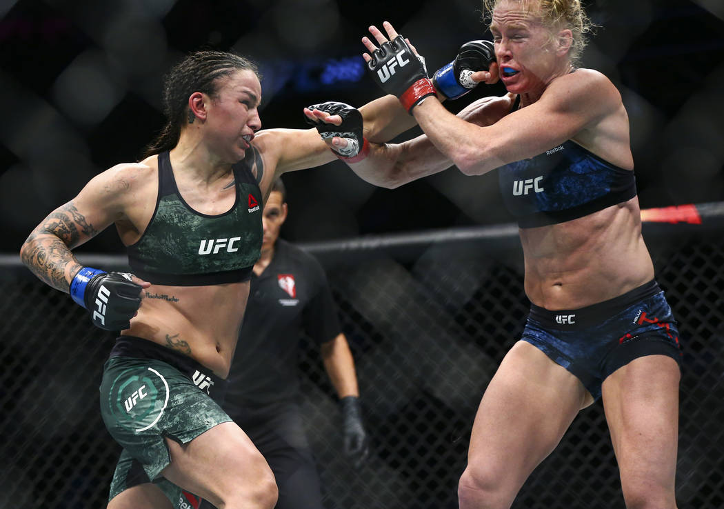 Holly Holm, right, takes a hit from Raquel Pennington during their bantamweight bout at UFC 246 ...