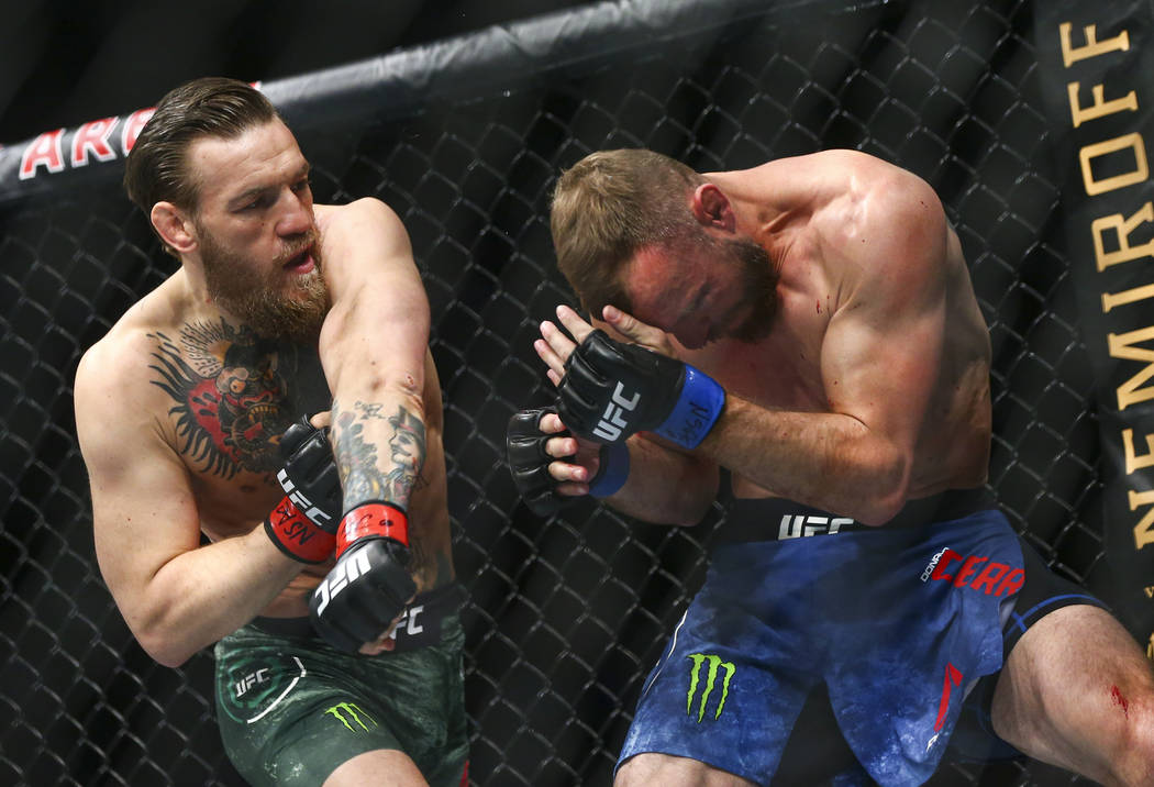 Conor McGregor, left, fights Donald "Cowboy" Cerrone during their welterweight bout a ...