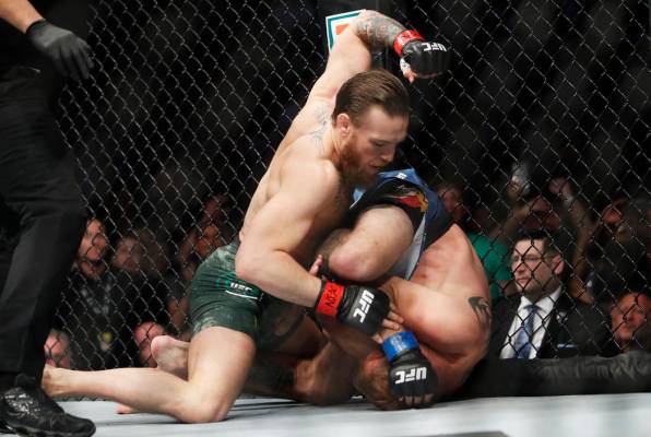 Conor McGregor, left, fights Donald "Cowboy" Cerrone during a UFC 246 welterweight mi ...