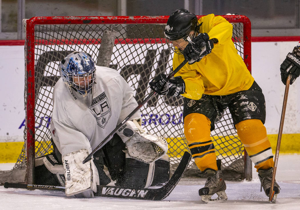 Team Redrum goalie John Hunt, left, deflects the puck while facing the Golden Knights in their ...