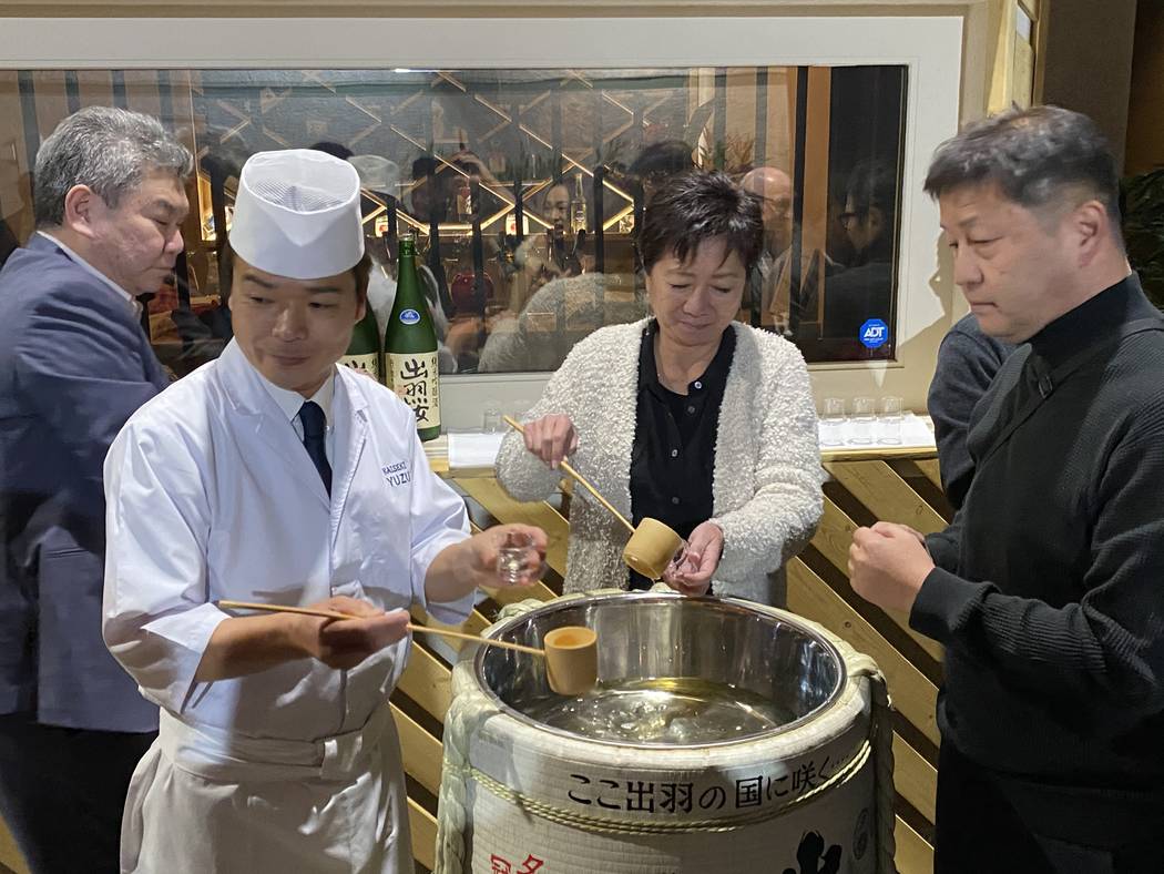 The team at Kaiseki Yuzu pour sake for guests at their relocation party on Jan. 18, 2020. (Al M ...
