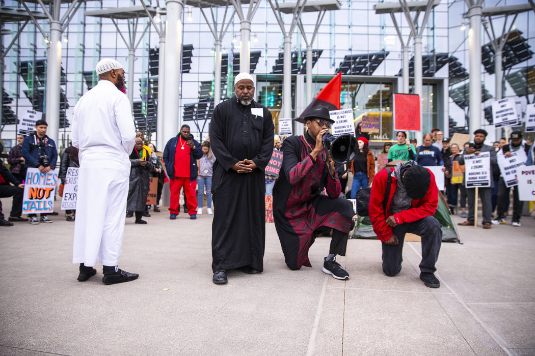 Minister Stretch Sanders, right center, leads a prayer as local activists rally at the Las Vega ...