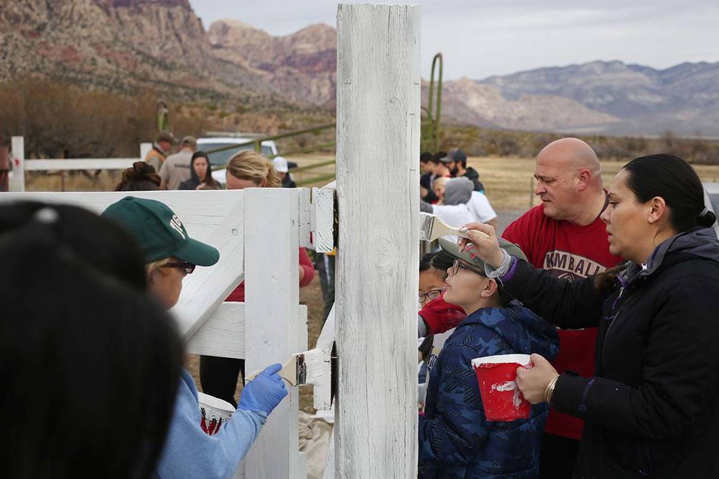 Volunteers with Scouts BSA paint a fence during their outreach day at Spring Mountain Ranch Sta ...