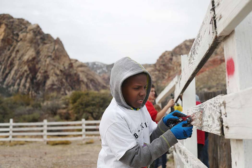 Jashon Cobbs, 11, with Scouts BSA of Las Vegas Troop 133, paints a fence during an outreach out ...