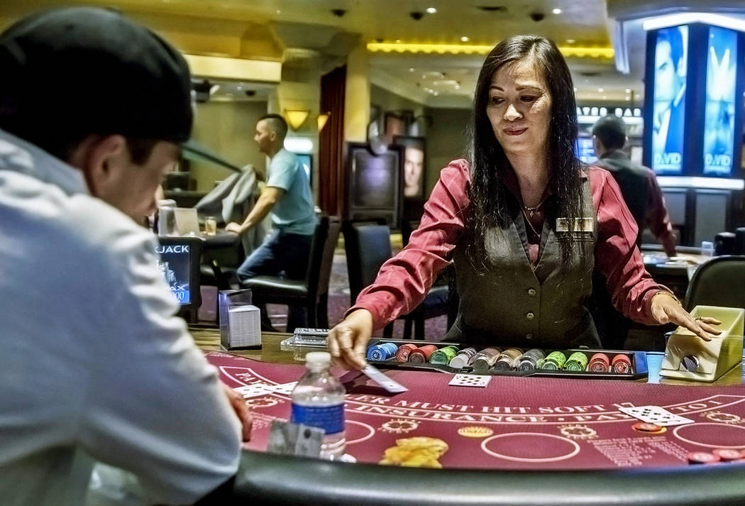 Table games dealer Dee Coffey, middle, deals blackjack at the MGM Grand hotel-casino on Thursda ...