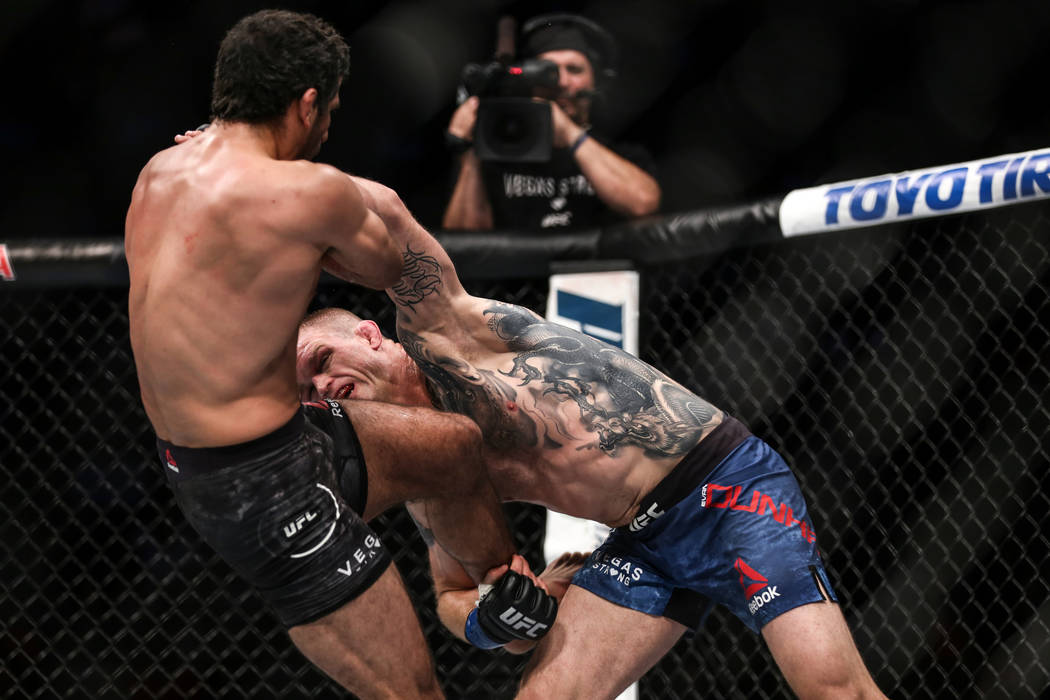 Beneil Dariush, left, is punched by Evan Dunham, right, during final round of the lightweight b ...