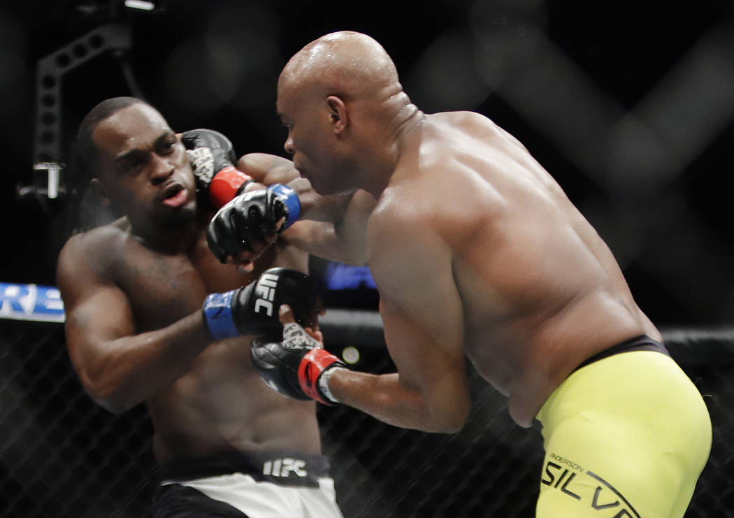 Anderson Silva, of Brazil, right, punches Derek Brunson during a middleweight mixed martial art ...