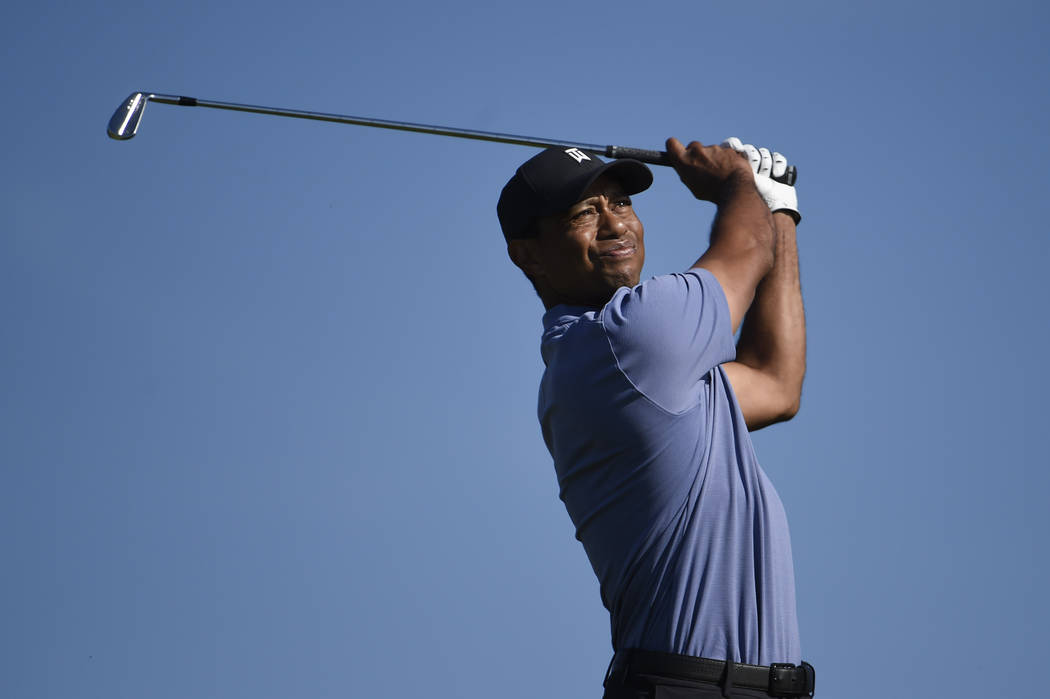Tiger Woods hits hit tee shot on the 15th hole of the North Course at Torrey Pines Golf Course ...