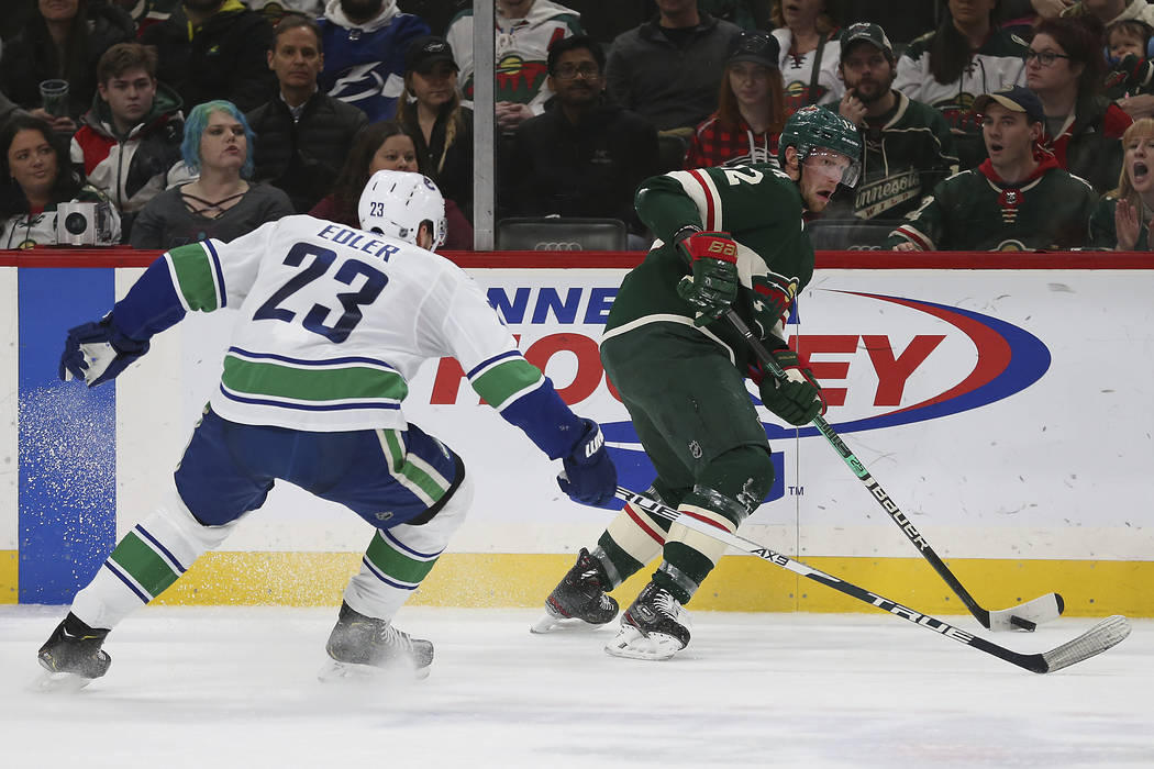 Minnesota Wild's Eric Staal, right, controls the puck against Vancouver Canucks' Alexander Edle ...