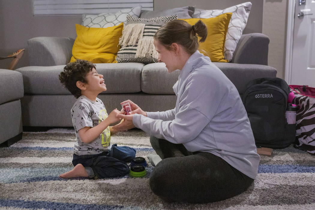 Rio Hansen, 3, works with Steffany Card, a speech-language pathologist, during a therapy sessio ...