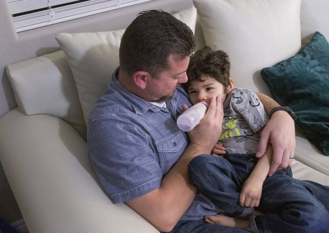 Mike Hansen gives his son, Rio, 3, PediaSure before Rio is put to sleep, in their home in Hende ...