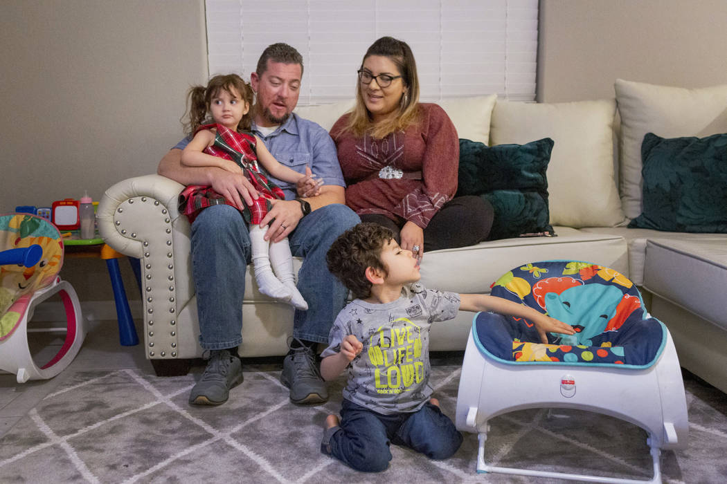 Mike and Cecilia Hansen sit with their children Luna, 2, left, and Rio, 3 in their home in Hend ...