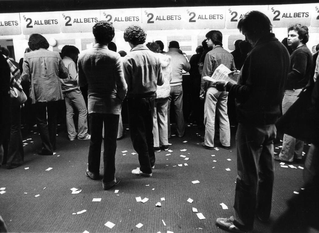 Bettors line up at windows at the Dunes race and sportsbook in a photograph from November 1981. ...