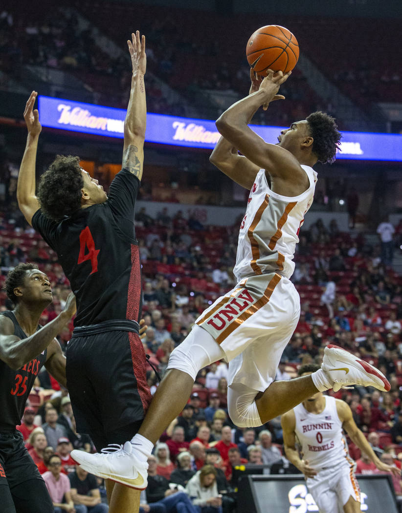 UNLV Rebels guard Bryce Hamilton (13, right) gets off a shot over San Diego State Aztecs guard ...